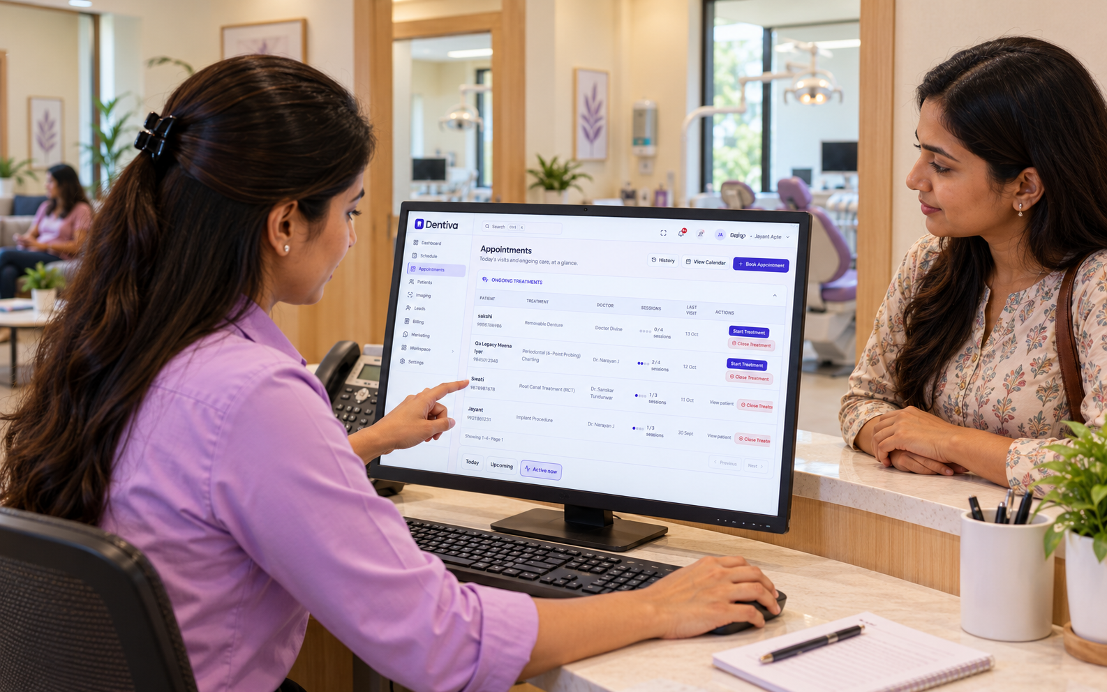 Receptionist discussing ongoing dental treatment visits with a patient at the clinic desk.
