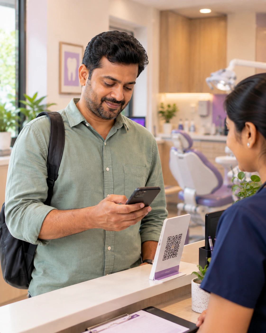 Patient using his phone to make a payment at the clinic desk beside a QR code stand.